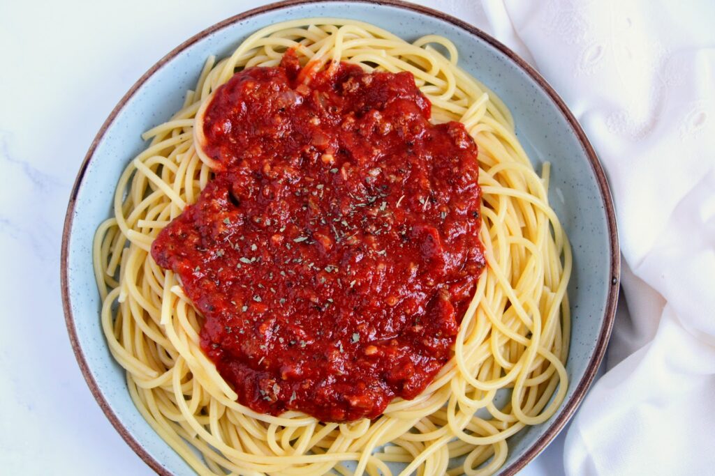Picture of spaghetti
 sauce on the stove with various ingredients