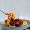 A fork with Spaghetti Noodles and Tomato Sauce