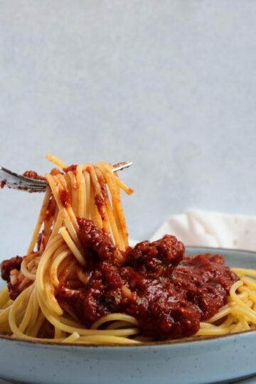 A fork with Spaghetti Noodles and Tomato Sauce
