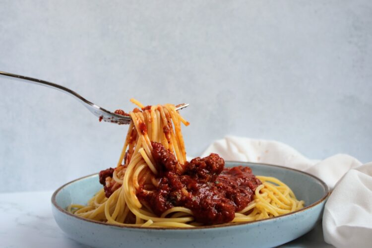 A fork with Spaghetti Noodles and Tomato Sauce