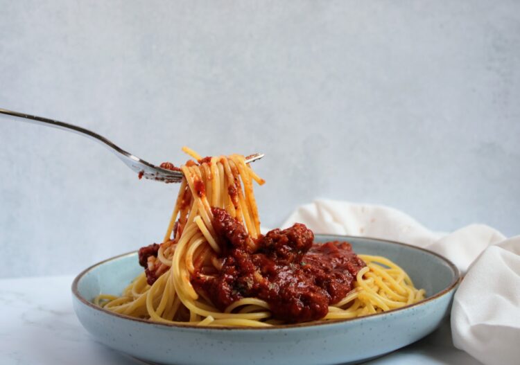 A fork with Spaghetti Noodles and Tomato Sauce